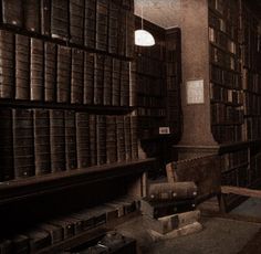 an old library filled with lots of books and boxes on the floor next to a chair