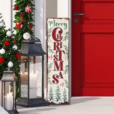 a red door with a merry christmas sign next to it and two lanterns on the front porch