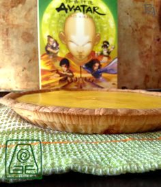 a close up of a pie on a table with a book in front of it