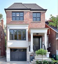 a two story brick house with black doors and windows on the second floor is shown