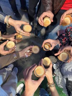 a group of people sitting around each other holding coffee cups in their hands and smiling