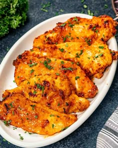 three pieces of chicken on a plate with parsley