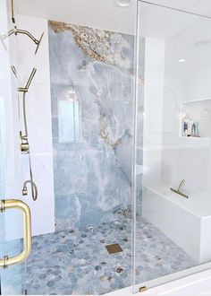 a bathroom with a walk in shower next to a white bathtub and a gold faucet