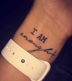 a wrist tattoo with the words i am, and an inscription on it that says i am