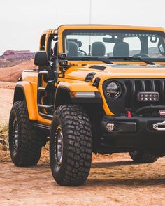 a bright yellow jeep is parked in the desert