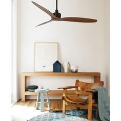 a ceiling fan in a living room next to a wooden table and chair with stools