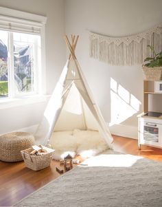 a teepee tent in the corner of a room with white walls and wood floors