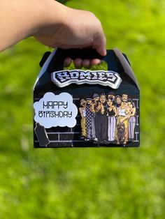 a person holding up a box with some stickers on it that says happy birthday