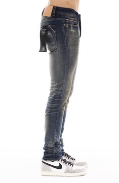 Slim-fitting stretch jeans feature a dimensional dark wash, subtle distressing and signature stitching at the back leg for an everyday edgy look. Zip fly with button closure Five-pocket style 89% cotton, 6% polyester, 5% spandex Machine wash, line dry Imported Urban Dark Wash Jeans With Frayed Hem, Rugged Fitted Denim Blue Bottoms, Fitted Rugged Denim Blue Bottoms, Rugged Fitted Jeans With Five Pockets, Fitted Faded Jeans In Rigid Denim, Fitted Rugged Rigid Denim Bottoms, Distressed Fitted Medium Wash Jeans, Rugged Fitted Straight Leg Jeans, Distressed Fitted Jeans In Medium Wash