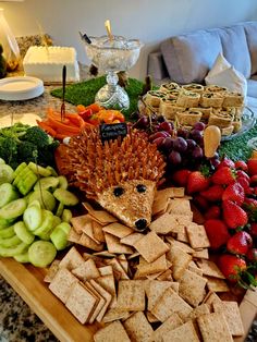 a tray filled with crackers, fruit and vegetables