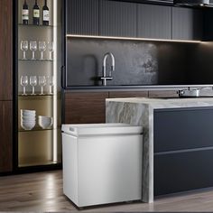 a modern kitchen with marble counter tops and black cabinetry, along with wine glasses on the shelves