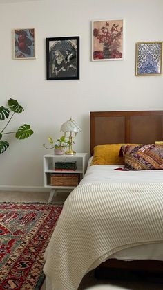 a bed sitting in a bedroom next to a wall with pictures on it