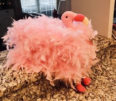 a stuffed flamingo sitting on top of a counter