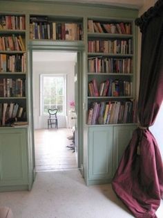 an open door leading to a room with bookshelves full of books in it