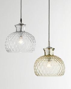 two glass pendant lights hanging from a ceiling