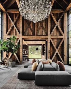 a living room filled with lots of furniture and a chandelier hanging from the ceiling