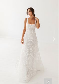 a woman in a white wedding dress posing for the camera with her hand on her face