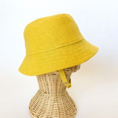 This yellow bucket hat is the perfect thing for babies toddlers and kids on sunny summer days! Washable linen and cotton fabirc makes it an easy go to for at the park, the beach, or even the backyard! This hat will protect delicate skin from the sun and will quickly become a favorite accessory! I made this sun hat from a bold yellow colored linen/cotton blend fabric. The strap closes with snaps under the chin keeps them from pulling it off. Brim measures approx. 2.25 inches. SIZES AVAILABLE 0-3 mos. - fits 14" to 16" head circumference 3-6 mos. - fits 15" to 17" head circumference 6-12 mos. - fits 16" to 18" head circumference 12-24 mos. - fits 17.5" to 19.5" head circumference Small (3 to 5 yrs) - fits 19" to 21" head circumference OVERVIEW + Sewn by me + Yellow Linen and Cotton blend Fab Cheap Yellow Cotton Bucket Hat, Adjustable Fit Cotton Brimmed Bucket Hat, Adjustable Cotton Sun Hat, Adjustable Cotton Bucket Hat With Wide Brim, Adjustable Fit Cotton Bucket Hat With Wide Brim, Adjustable Cotton Wide Brim Bucket Hat, Adjustable Summer Cotton Bucket Hat, Solid Color Cotton Sun Hat For Summer, Cotton Summer Sun Hat