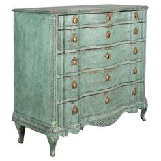 an old green dresser with gold knobs on the top and bottom drawers, against a white background