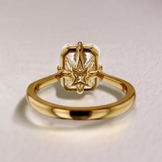 a yellow gold ring with a white diamond in the center on a plain surface,