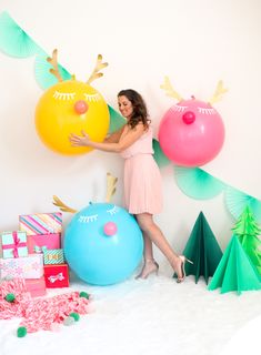 a woman standing next to balloons and presents