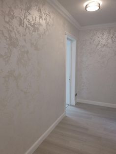 an empty room with white walls and wood flooring is seen in this image from the doorway