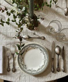 the table is set with silverware and flowers