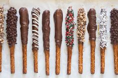 chocolate covered pretzels lined up in a row with sprinkles on them