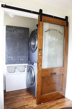 a washer and dryer sitting in front of a chalkboard on the wall