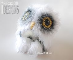 an owl stuffed animal with yellow eyes and white fur on it's head, sitting in front of a white background