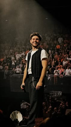 a man standing on top of a stage in front of a crowd