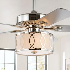 a ceiling fan that is hanging from the ceiling in a room with white walls and windows