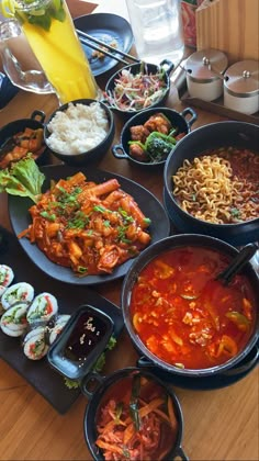 a table topped with lots of different types of food on black plates next to each other