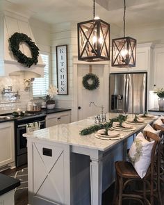 an instagram photo of a kitchen with white cabinets and counter tops, surrounded by wreaths on the island