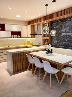 a kitchen with a chalkboard on the wall and white chairs