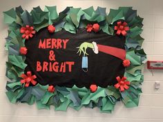 a merry and bright sign hanging from the side of a wall with paper poinsettis