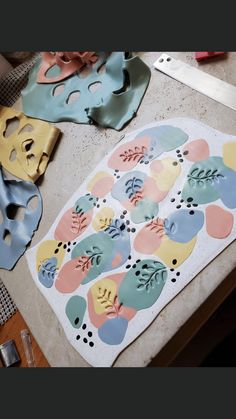 some masks are laying on a table with paper and scissors next to them, along with other crafting supplies