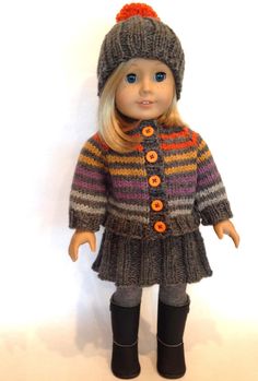 the doll is wearing a knitted coat and hat