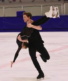 two people skating on an ice rink with one holding the other's leg up