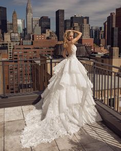 a woman in a wedding dress standing on top of a building