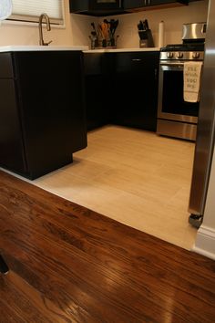 a kitchen with wood floors and stainless steel appliances