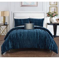 a bed with blue comforter and pillows