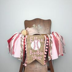 an old chair with a baseball banner on it's back and some other items hanging from the back