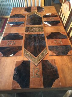 a wooden table topped with lots of brown and white cowhide