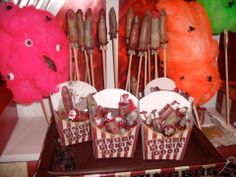 some food items are sitting on sticks in front of other foods and decorations that look like they have been made out of candy