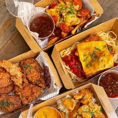 four boxes filled with different types of food on top of a wooden table next to drinks