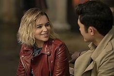 a woman sitting next to a man in a red leather jacket on a street corner