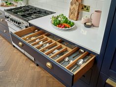 an open drawer in the middle of a kitchen