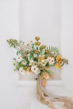 a bouquet of flowers sitting on top of a white shelf