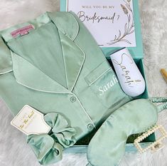 an open box containing a green robe, hairdryer, and other personal items